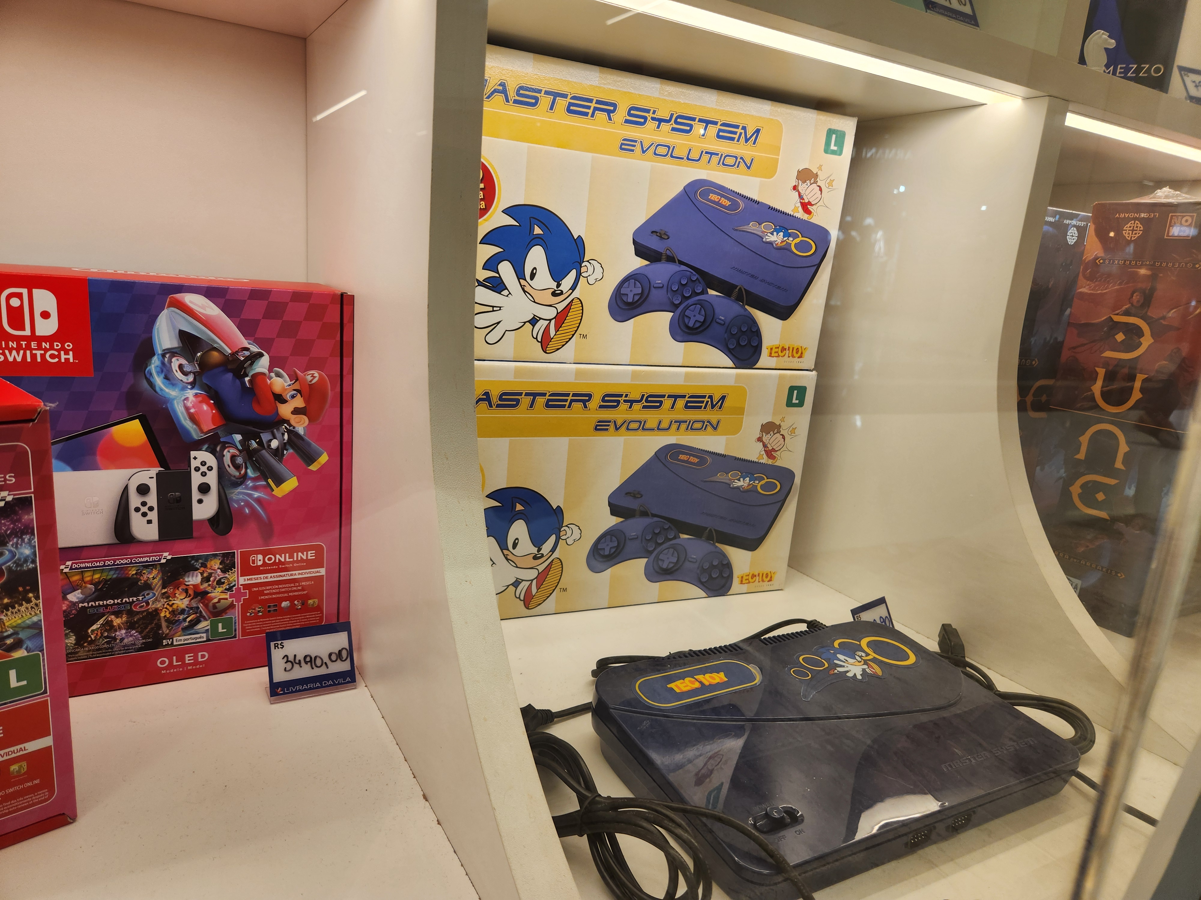 A Brazilian bookstore's display window showing a Nintendo Switch right besides a Master System